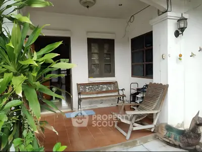 Charming patio with wooden seating and lush greenery, perfect for relaxation.