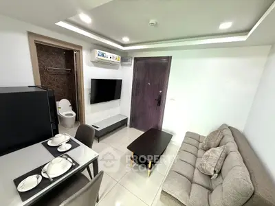 Modern living room with sleek furniture and integrated dining area, featuring a wall-mounted TV and air conditioning.