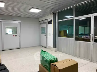 Spacious industrial-style room with large windows and modern doors, ideal for office or storage use.