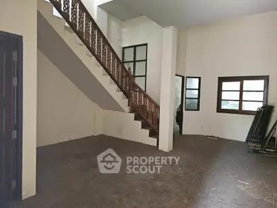 Spacious interior with staircase and large windows, ideal for customization.