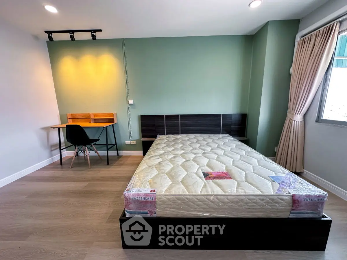 Modern bedroom with stylish desk and large window for natural light.