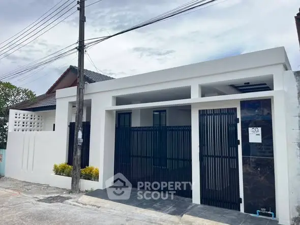 Modern minimalist house exterior with gated entrance and clean lines