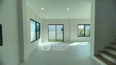 Spacious modern living room with large windows and abundant natural light