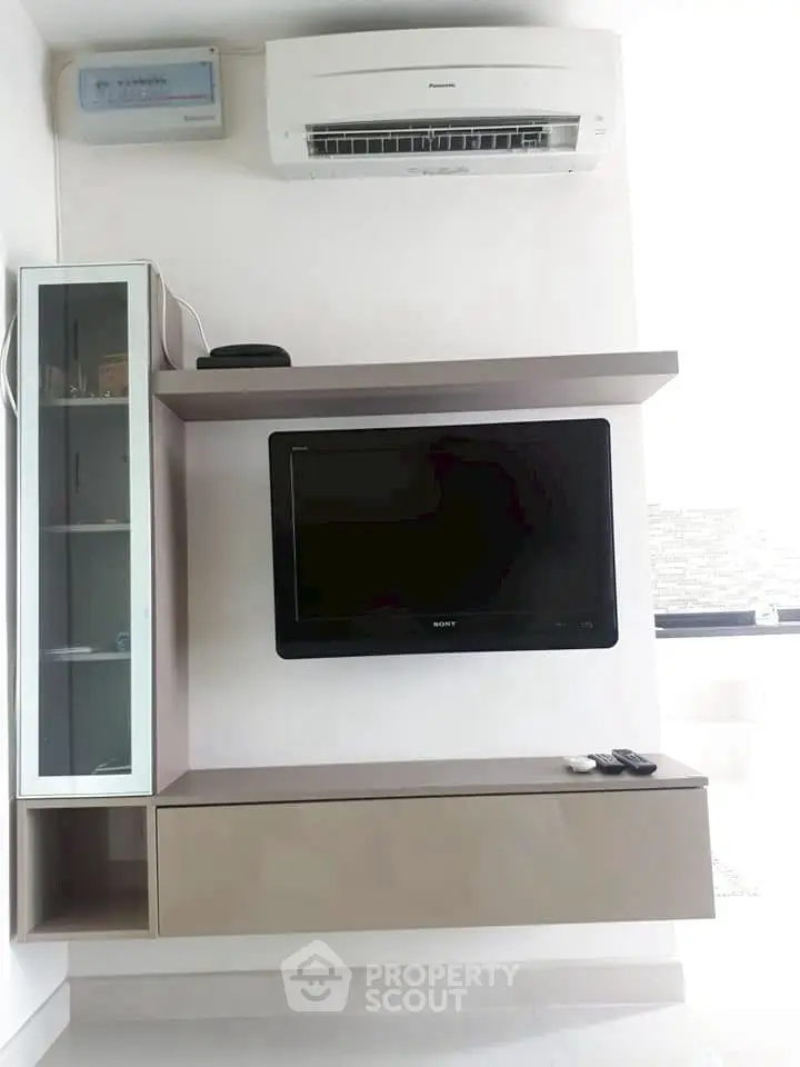 Modern living room with sleek TV setup and air conditioning unit