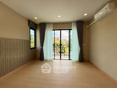 Spacious empty room with large window and air conditioning, perfect for customization.