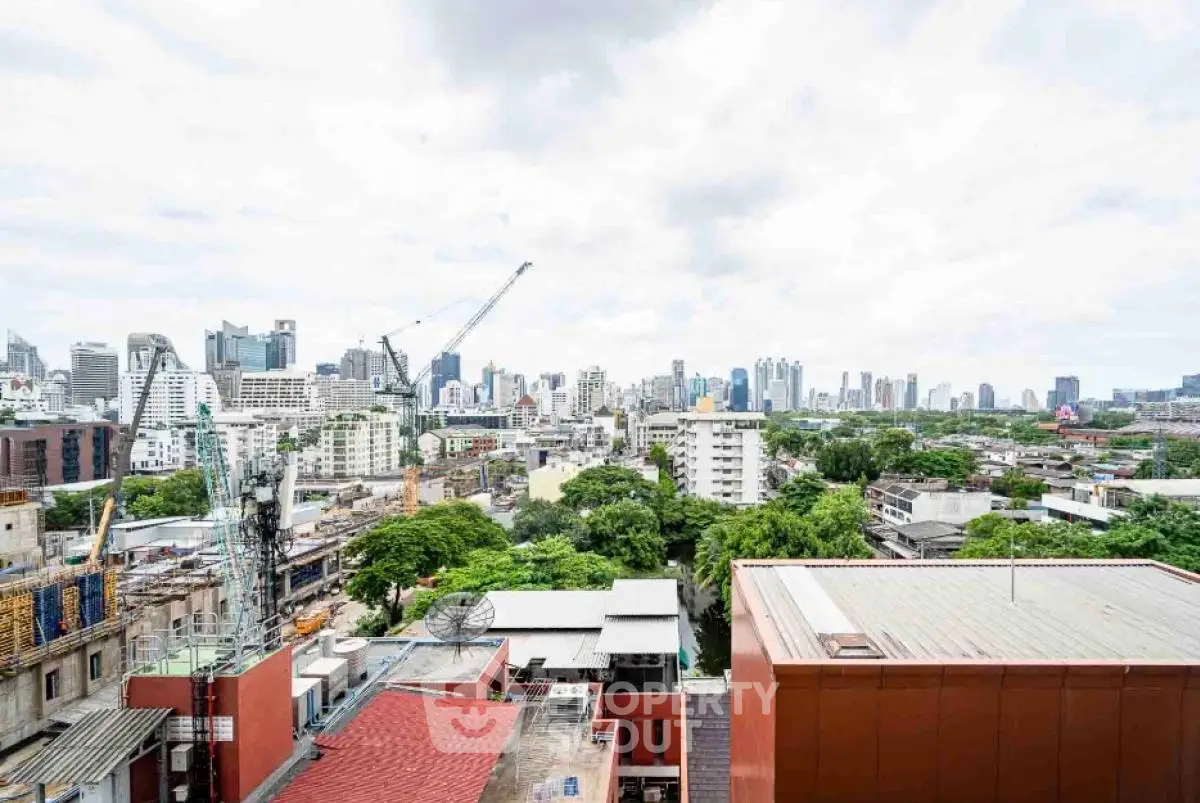 Stunning cityscape view from high-rise building showcasing urban skyline and greenery.