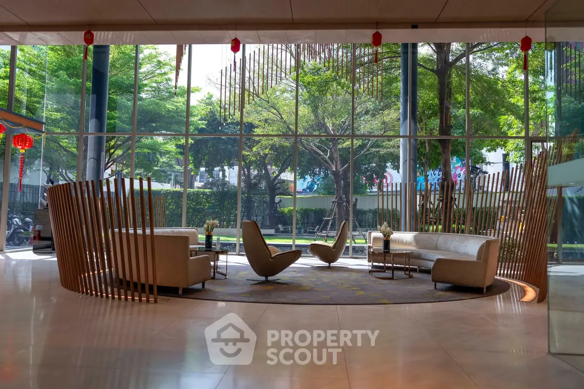 Luxurious modern lobby with stylish seating and large windows overlooking lush greenery.