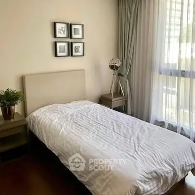 Cozy bedroom with natural light and modern decor, perfect for relaxation.