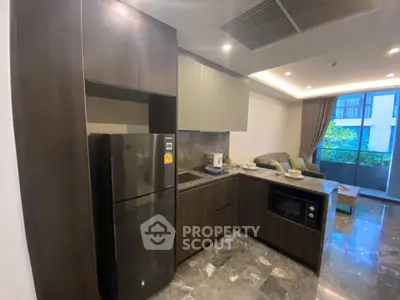 Modern kitchen with sleek cabinetry and appliances in open layout apartment