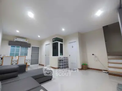 Spacious modern living room with sleek furniture and bright lighting, perfect for family gatherings.