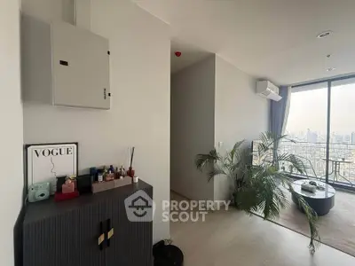 Modern living room with city view, stylish decor, and large windows for natural light.