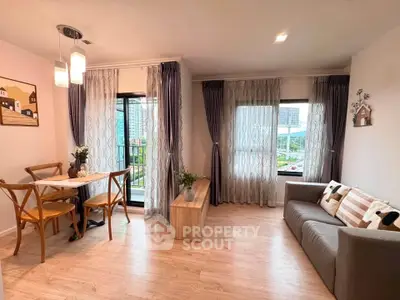 Charming living room with dining area, large windows, and stylish decor in modern apartment.