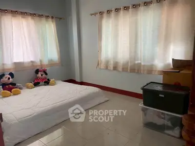 Cozy bedroom with large windows and simple decor, perfect for relaxation.