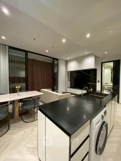 Modern open-plan kitchen and living area with sleek design and integrated appliances.