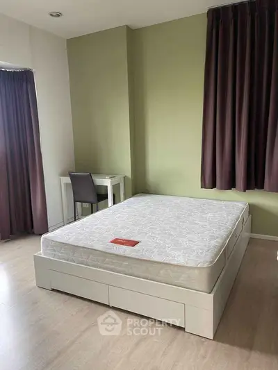 Spacious bedroom with modern decor and natural light, featuring a comfortable bed and study area.
