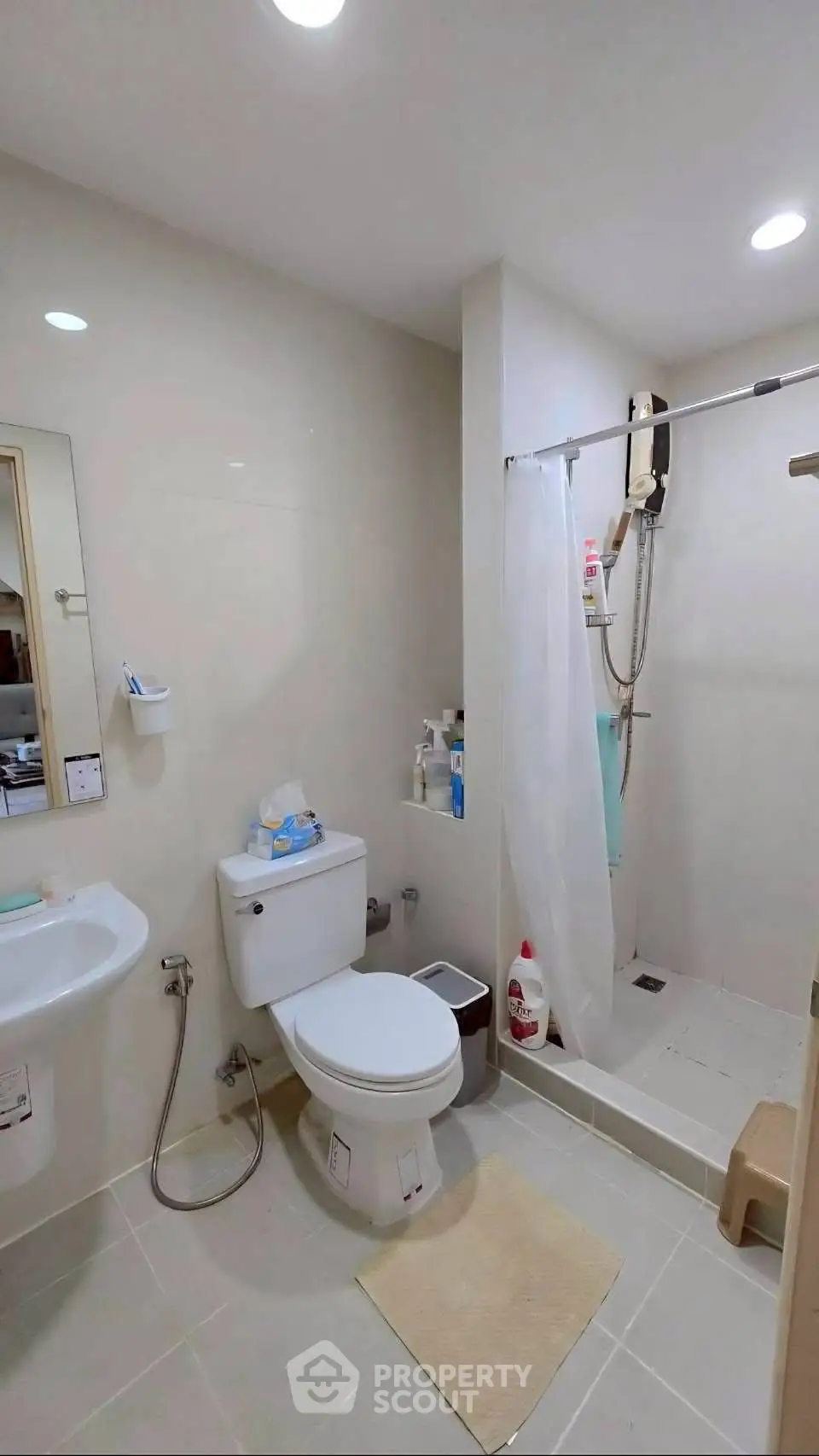 Modern bathroom with shower and toilet in a sleek minimalist design.