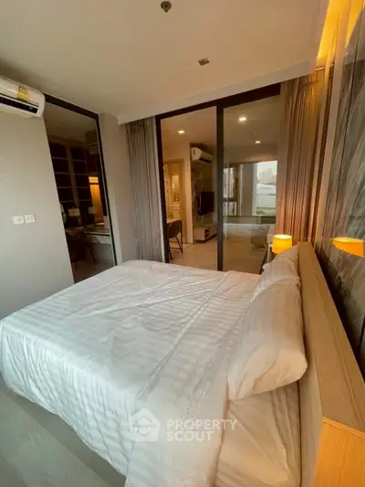 Modern bedroom with elegant decor and large windows offering natural light