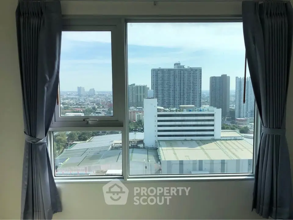 Stunning cityscape view from a high-rise apartment window with modern curtains.