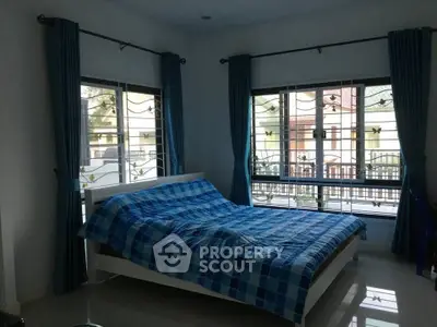 Spacious bedroom with large windows and blue decor in modern home