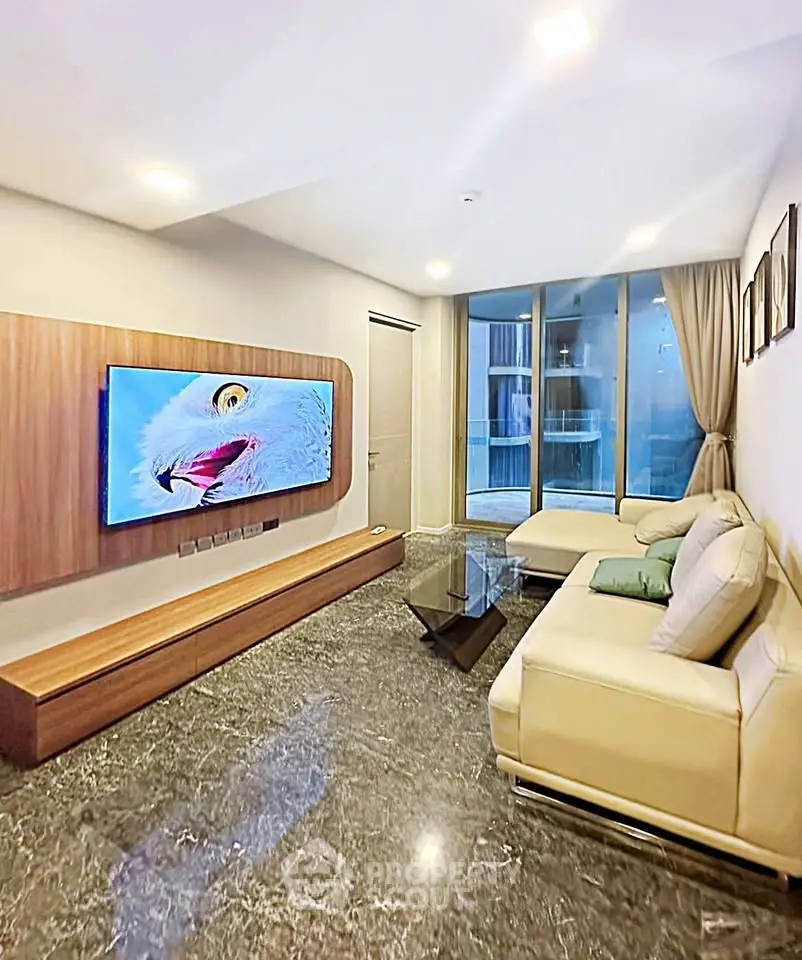 Luxurious living room with modern decor, marble flooring, and large TV, perfect for relaxation and entertainment.