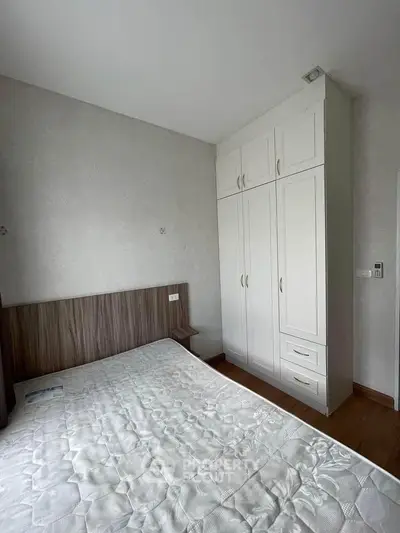 Cozy bedroom with built-in wardrobe and wooden flooring, perfect for modern living.