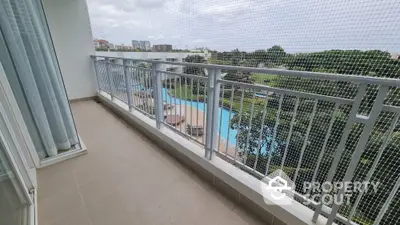 Spacious balcony with pool view in modern apartment complex