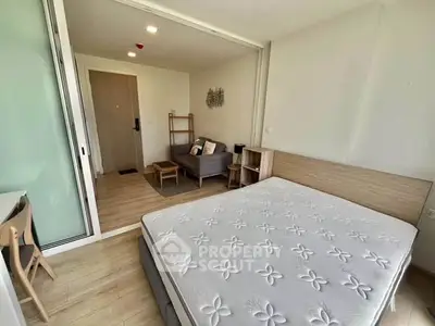 Modern studio apartment with cozy living area and comfortable bed, featuring stylish wooden flooring and natural light.