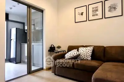 Modern living room with cozy sofa and open kitchen layout in stylish apartment.