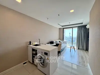 Modern open-plan living room with city view and in-unit washing machine.