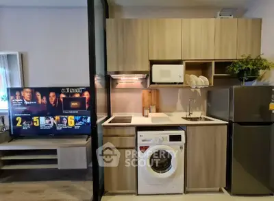 Modern compact kitchen with washing machine and microwave in stylish apartment.