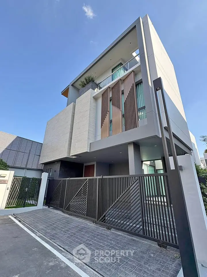 Modern three-story house with sleek design and gated entrance