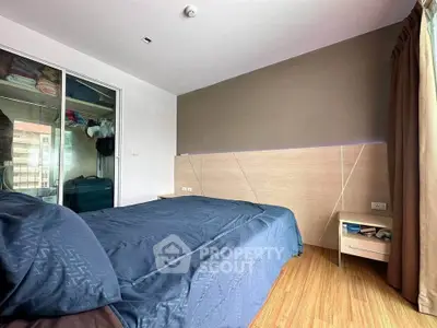 Modern bedroom with wooden flooring and large closet in stylish apartment.