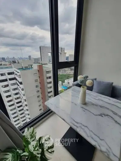 Stunning city view from modern high-rise apartment with elegant marble table.