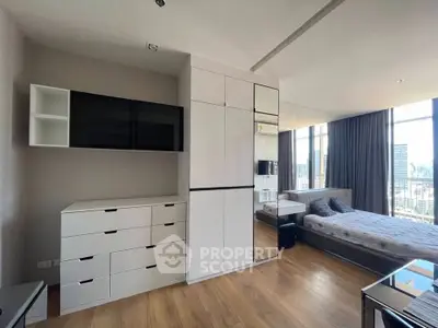 Modern bedroom with sleek storage and city view, featuring large windows and stylish decor.
