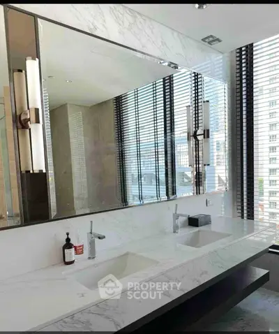 Luxurious modern bathroom with dual sinks and large mirror in high-rise apartment.