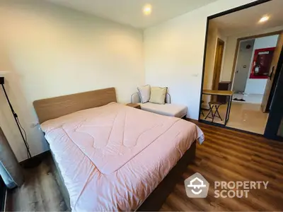 Modern bedroom with wooden flooring and cozy decor in a stylish apartment.