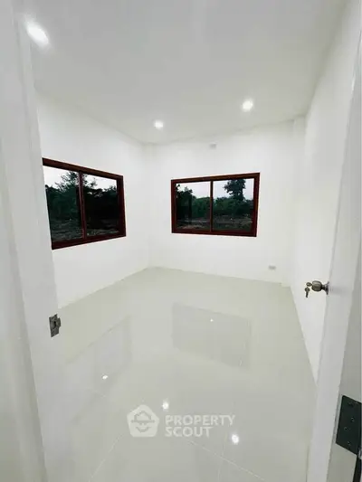 Bright empty room with large windows and glossy white tiles