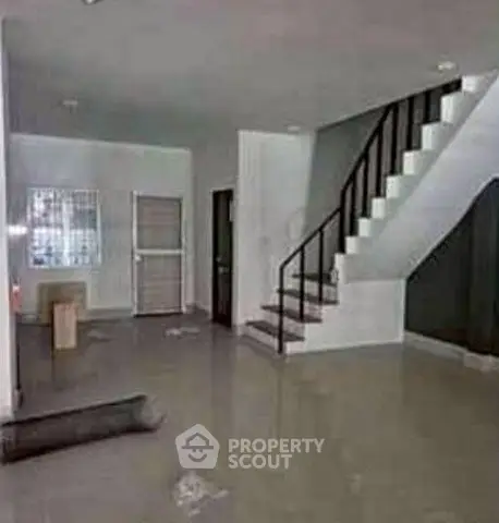 Spacious open-plan living area with staircase, ideal for modern family living.