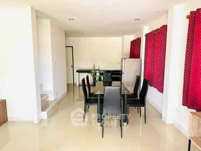 Spacious dining area with modern black furniture and vibrant red curtains, perfect for family gatherings.