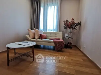 Chic living room with modern sofa, elegant decor, and natural light through large window.