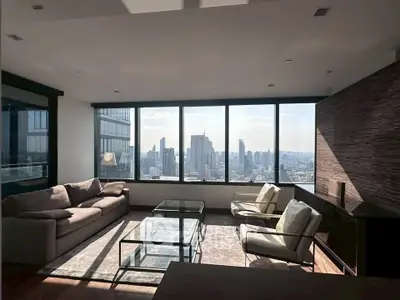 Luxurious living room with stunning city skyline view and modern furnishings.