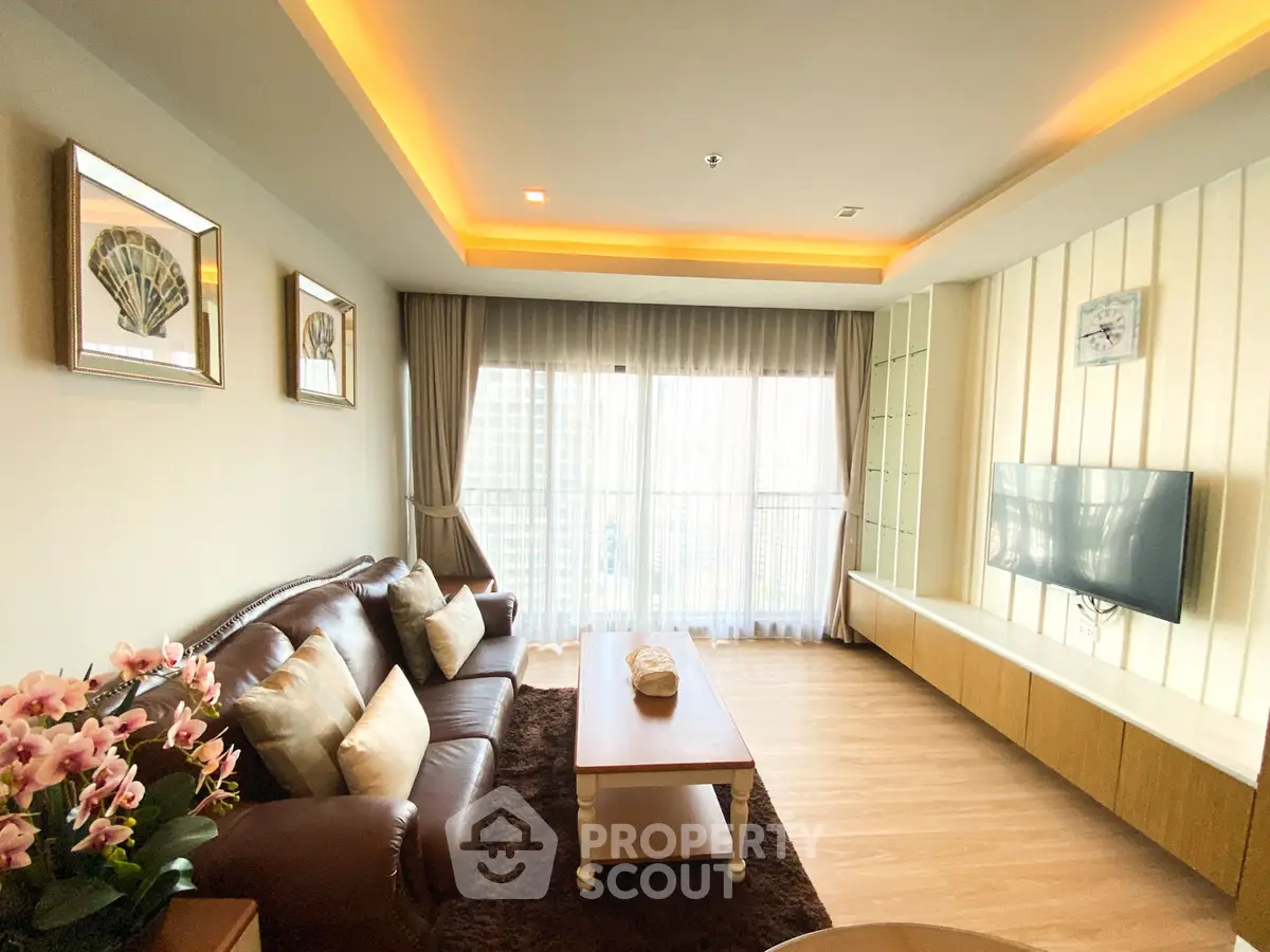 Spacious living room with elegant decor and large windows offering natural light.