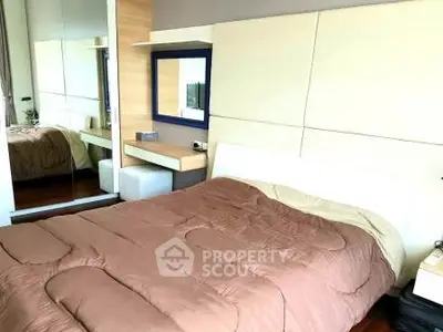 Modern bedroom with cozy bedding and mirrored wardrobe in stylish apartment.