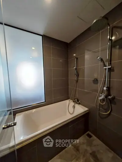 Modern bathroom with sleek design featuring a bathtub and dual shower heads.