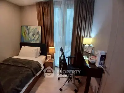 Cozy bedroom with modern decor, featuring a single bed, desk, and warm lighting.