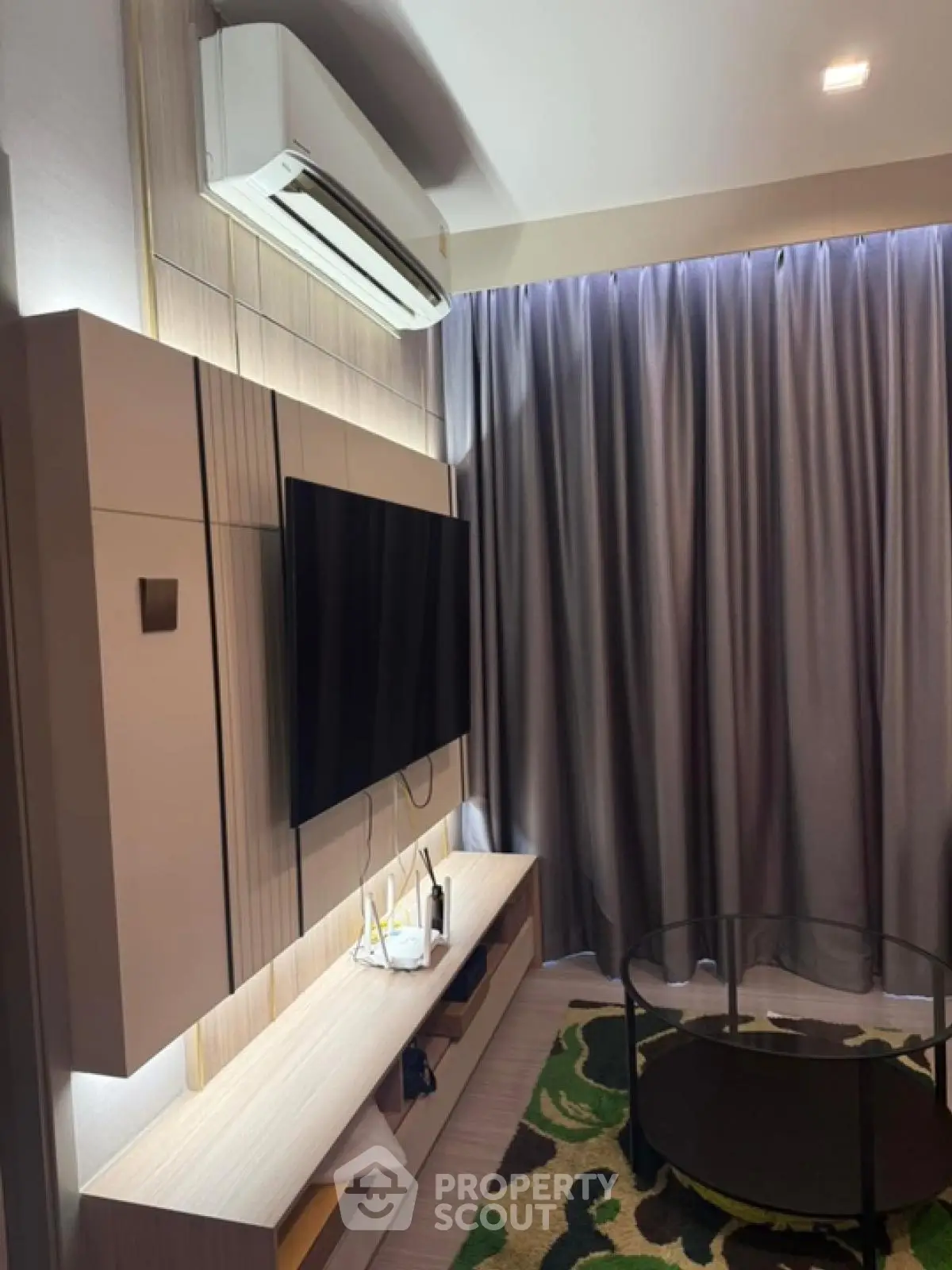 Modern living room with sleek TV setup and air conditioning