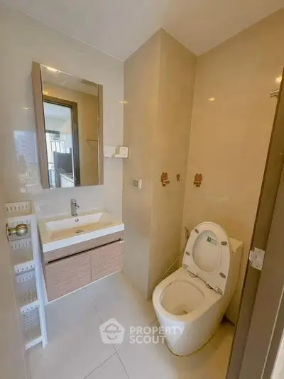 Modern bathroom with sleek fixtures and large mirror in a contemporary apartment.