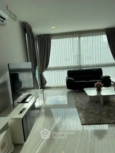 Spacious living room with modern decor and large windows for natural light.