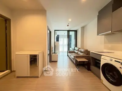 Modern apartment interior with open layout, featuring a cozy living area and in-unit washing machine.