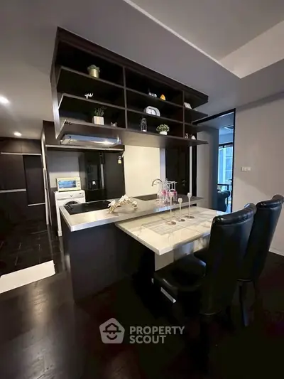 Modern kitchen with open layout and sleek dark cabinetry